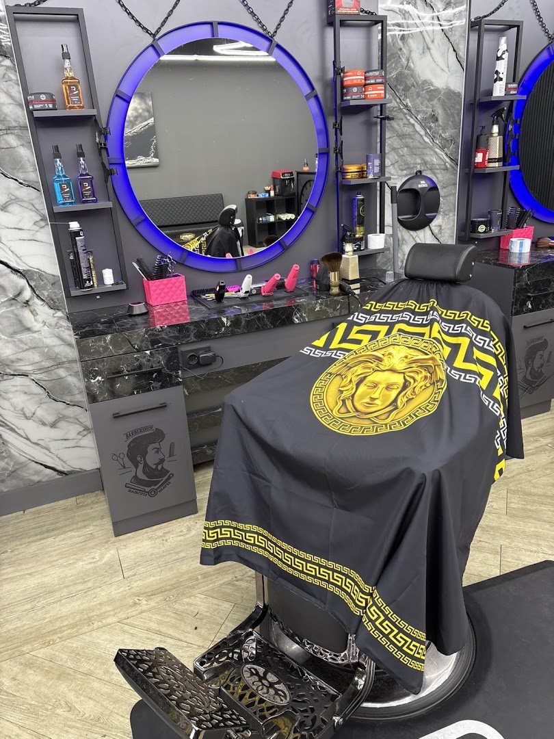 Interieur van Barber Star: ronde spiegel met blauw LED-licht, zwart marmer en gouden Versace-kappersschort
