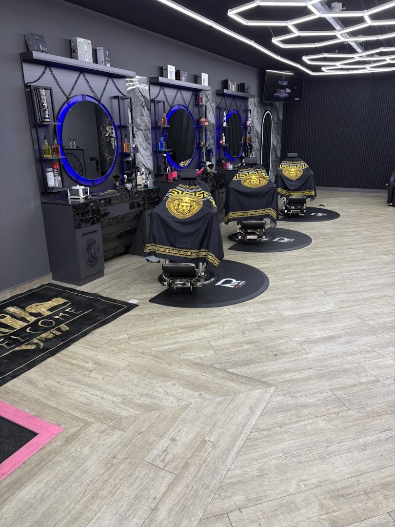De kappersstoelen van Barber Star met blauw verlichte spiegels en gouden Versace-schorten